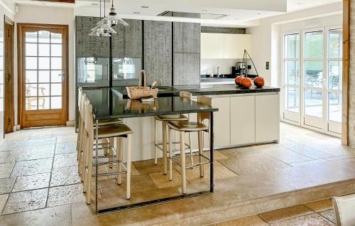 a kitchen with a large island with bar stools at 5 Bedroom Beautiful Home In Fauverney in Fauverney
