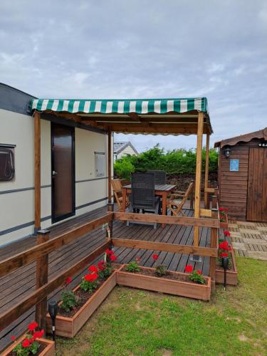 een huis met een terras met een tafel en een tuinhuisje bij Mobil home inter in Berck-sur-Mer