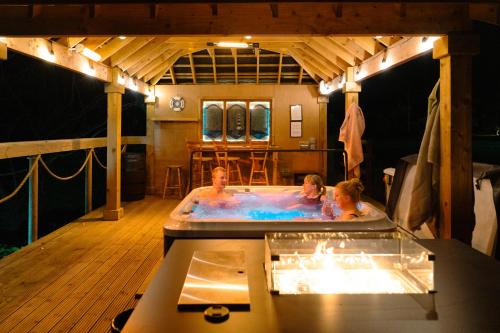 Due persone in una vasca idromassaggio in una casa di Luxury Accommodation in County Antrim with Riverside Hot Tub a Kells