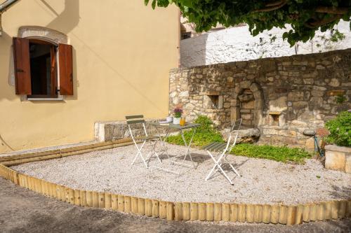 two chairs sitting on the ground in front of a building at liofito village house in Pemónia