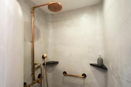 a bathroom with a shower with shelves on the wall at Dunas Luxury Beach Resort Tarifa in Tarifa