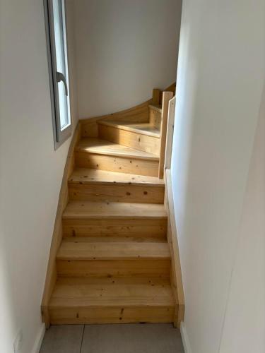- un escalier en bois dans une chambre avec fenêtre dans l'établissement Magnifique T2 neuf au centre de Cambo les bains, à Cambo-les-Bains