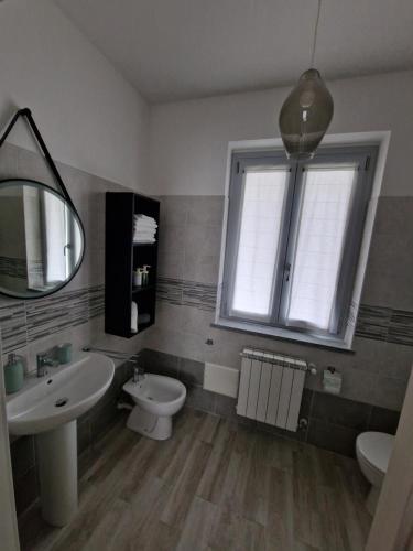 a bathroom with a sink and a toilet and a window at Locanda La Guienda in Torre Canavese