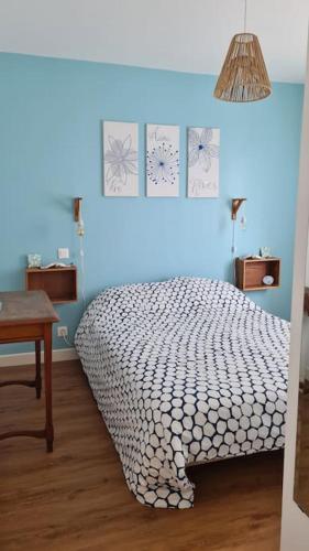 une chambre avec un lit et un mur bleu dans l'établissement Villa rénovée 350 m de la mer, à Hauteville-sur-Mer