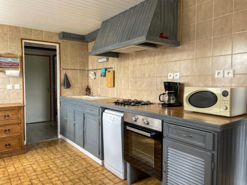 una cucina con forno a microonde e piano cottura forno superiore di Gîte de la tuilerie des Garandons a Saint-Menoux