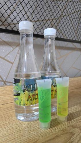 two bottles of water and two glasses on a table at Khaosan Art Hotel in Bangkok