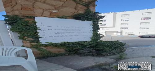 a sign on the side of a building with ivy at Appartement a louer au Nord du maroc fnideq in Fnidek