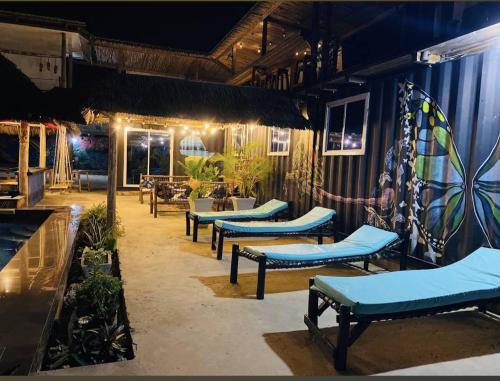 a restaurant with blue benches and a patio at night at Jambiani Backpackers Hostel in Jambiani