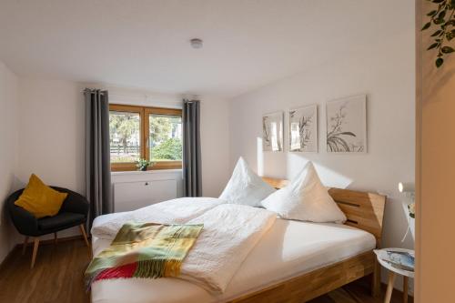 une chambre avec un lit avec des draps blancs et une fenêtre dans l'établissement Familien - 3 SZ - Terrasse mit Bergblick - 2 Parkplätze, à Fügen