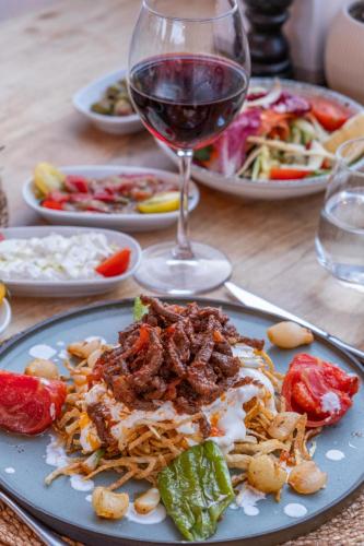 a table with plates of food and a glass of wine at Paloma Family Club in Bitez