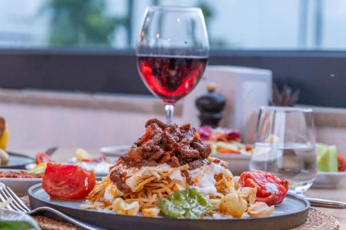 a plate of food and a glass of red wine at Paloma Family Club in Bitez