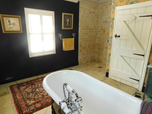 baño con bañera, ventana y puerta en Willow Cottage Accommodation en Sligo