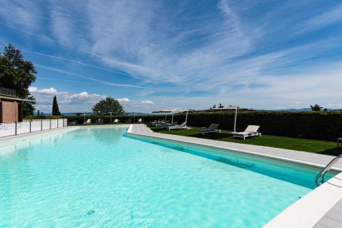 een groot zwembad met blauw water bij Cappuccina Country Resort in San Gimignano