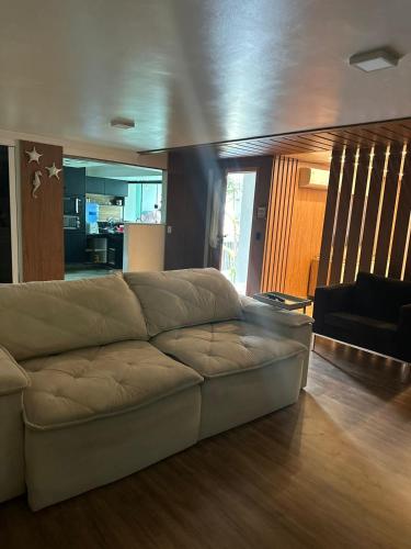 a living room with a brown couch in a room at Casa pertinho da praia com hidro in Rio das Ostras