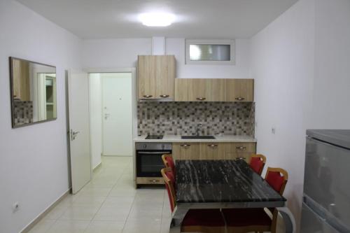 a kitchen with a table and a stove top oven at Blue Apartments & Hotel Shengjin in Shëngjin