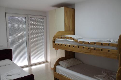 two bunk beds in a room with a window at Blue Apartments & Hotel Shengjin in Shëngjin
