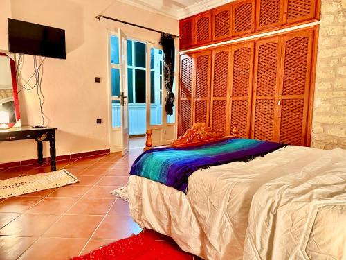 a bedroom with a large bed with a wooden headboard at QUIET OASIS Luxury Stone Villa with Panoramic Views near Essaouira in Essaouira