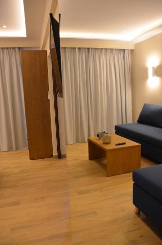 uma sala de estar com um sofá e uma mesa de centro em Odysseus Hotel em Paleokastritsa