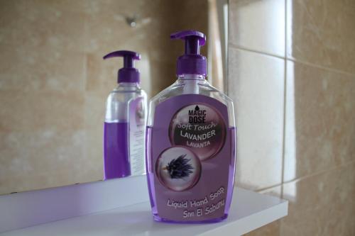 two bottles of soap sitting on a shelf in a bathroom at Blue Apartments & Hotel Shengjin in Shëngjin