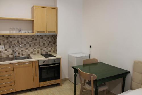 a small kitchen with a green table and a sink at Blue Apartments & Hotel Shengjin in Shëngjin