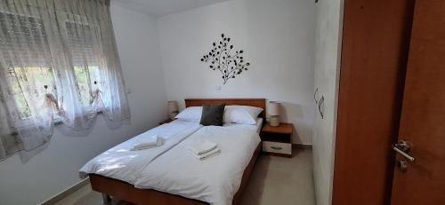1 dormitorio pequeño con 1 cama con sábanas blancas en Apartments Casa Karmen, en Pula