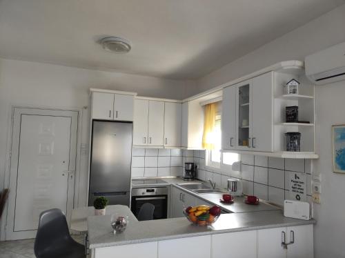 a kitchen with white cabinets and a counter top at Maries sea view house in Skala Marion