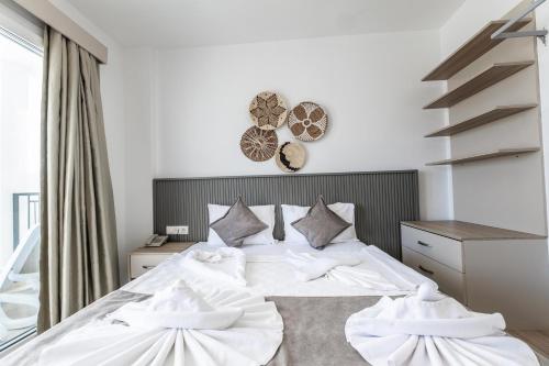 a bedroom with a bed with white sheets and pillows at Paloma Family Club in Bitez