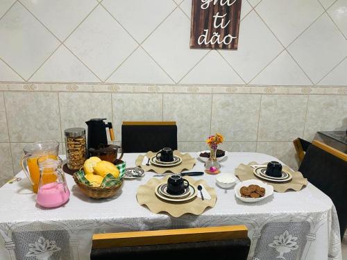 HOSTEL ANPRADO في جوارولوس: طاولة عليها قماش الطاولة البيضاء مع الطعام