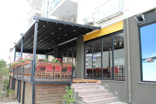 a building with a balcony with red chairs on it at Blue Apartments & Hotel Shengjin in Shëngjin
