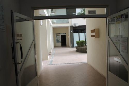 an empty hallway in a building with a door open at Blue Apartments & Hotel Shengjin in Shëngjin