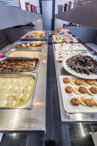 a buffet line with many different types of donuts at Paloma Family Club in Bitez