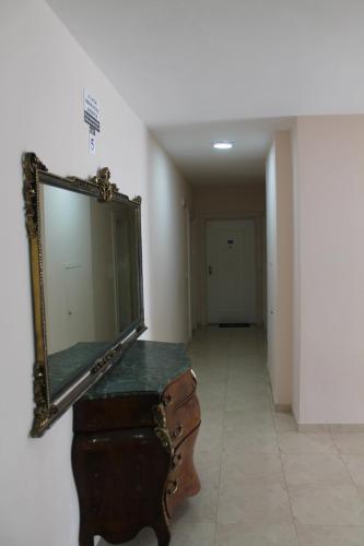a mirror sitting on top of a dresser in a hallway at Blue Apartments & Hotel Shengjin in Shëngjin