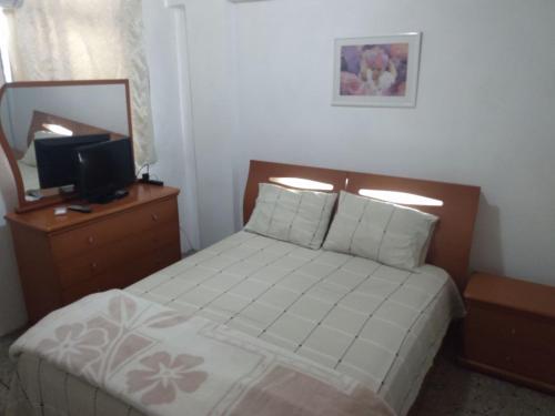 a bedroom with a bed and a mirror and a television at Habitación para una persona in Puerto La Cruz
