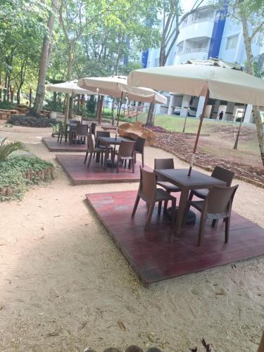 a group of tables and chairs with umbrellas at Apart no Águas da Serra - 115B in Rio Quente