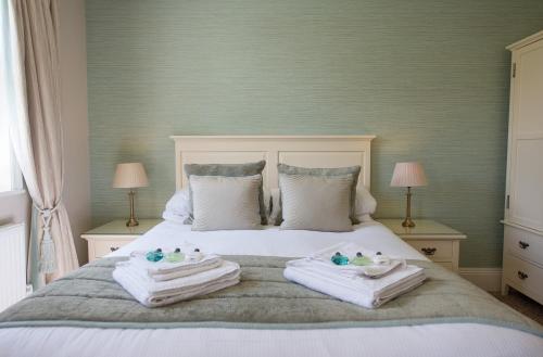 a bedroom with a bed with towels and two lamps at Bartley Lodge Hotel in Lyndhurst