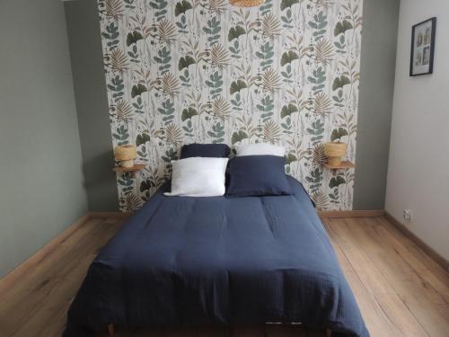 Cette chambre comprend un lit avec deux oreillers et du papier peint. dans l'établissement Maison aux portes de Chambord-zoo Beauval 40 mn, à Bracieux