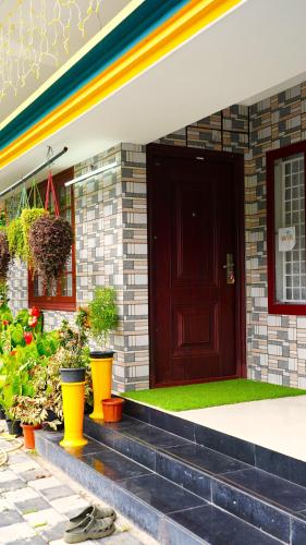 a front door of a house with plants on the steps at Arabian Nights Munnar Pool Villa in Munnar