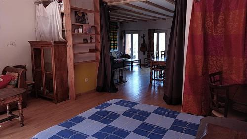 a bedroom with a bed and a living room at Gîtes de Revirand in Sarras