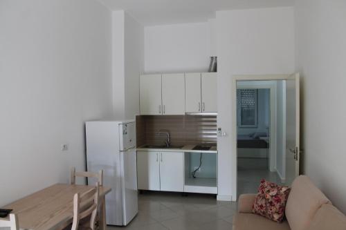 a kitchen and a living room with a couch and a table at Blue Apartments & Hotel Shengjin in Shëngjin