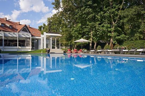 una gran piscina azul frente a una casa en Normafa Hotel en Budapest
