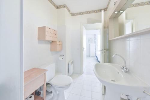 une salle de bain blanche avec des toilettes et un lavabo dans l'établissement PALM ROYAL - Apt for 4 with balcony - 5 minutes from the beach, à Antibes
