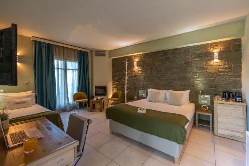 a hotel room with a large bed and a desk at Rouista Tzoumerka Resort in Vourgareli