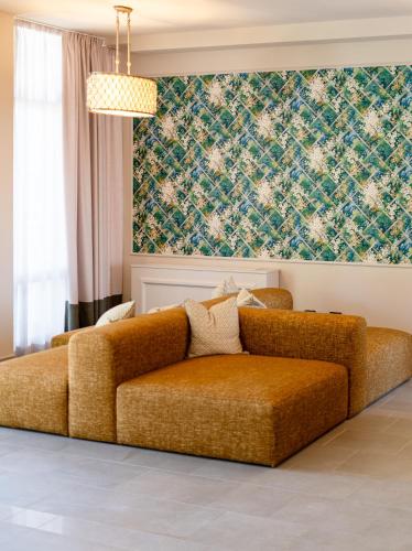 a couch in a living room with a wall at Cappuccina Country Resort in San Gimignano