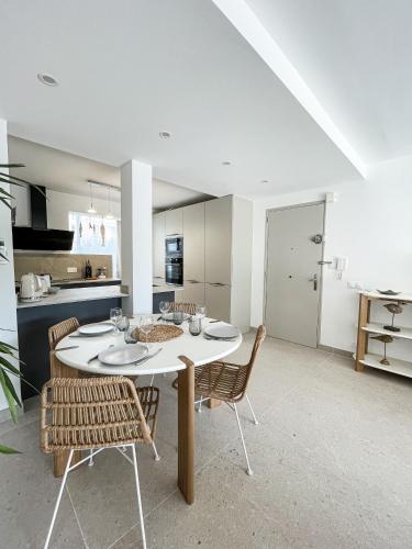 une cuisine et une salle à manger avec une table et des chaises dans l'établissement Immersione - Clim - Terrasse Jardin - Centre ville, à Cassis