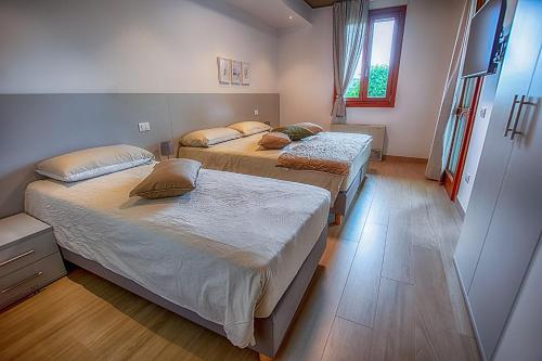 1 dormitorio con 2 camas y ventana en Hotel Residence Dolcenero en San Daniele del Friuli