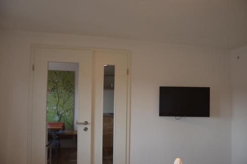 a flat screen tv on a wall next to a door at Beim Bergschreiner in Obergünzburg