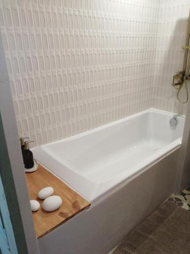a bathroom with a white bath tub with two white toilets at Un petit bout du monde in Saint-Georges-en-Couzan
