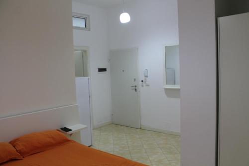 a bedroom with white walls and a bed and a shower at Blue Apartments & Hotel Shengjin in Shëngjin