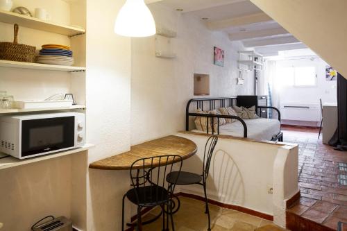 une petite pièce avec un lit, une table et des chaises dans l'établissement FRIOUL, à Marseille