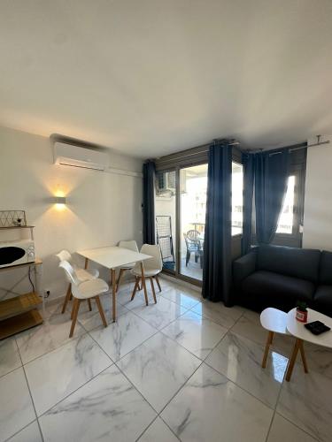 un salon avec un canapé, une table et des chaises dans l'établissement Résidence Graziella Studio 403, à Juan-les-Pins